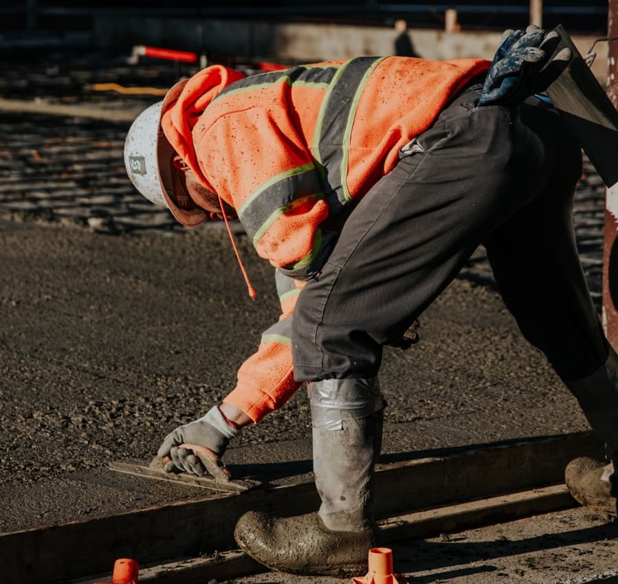 Ouvrier lissant une dalle de béton sur un chantier